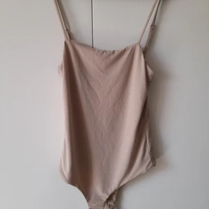 Body - String body knappt använd.reglerbara band,skön,luftigt material.knäpper med 2 knappar där under.