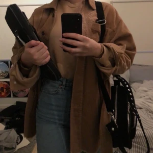 Snygg manchesterjacka från Zara - As inne och snygg brun manchester jacka köpt på Zara förra året, använt lite men jättebra skick! Jätteinne färg och najs längd, kan knytas snyggt i midjan eller ha öppen. Är varmare än den ser ut! 