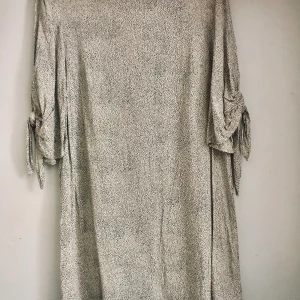 Klänning  - Vit och svart prikig klänning! Med en slits på axlarna! Storlek M! Aldrig använd❤️ klänningen går på mig över knäna, jag är ca 170