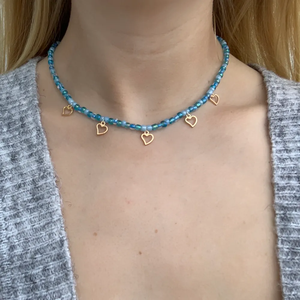 Blått pärlhalsband med små söta guldhjärtan 🦋💙💕⭐️🥺🤩 halsbandet försluts med lås och tråden är elastisk . Accessoarer.