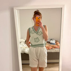 Väst med blommor - En vit väst från asos med gröna blommor, aldrig använd. Stor storlek men passar XS-L beroende på önskad passform