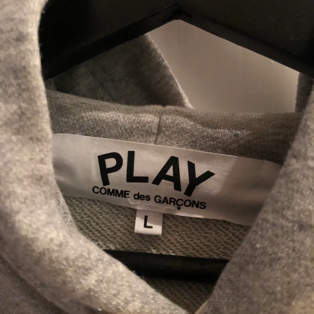 Grå Comme des Garcons play hoodie i väldigt fint skick och använd 2 gånger. Storleken är L men mer som M. Jag köpte den från End clothing för 2600kr. Tröjor & Koftor.