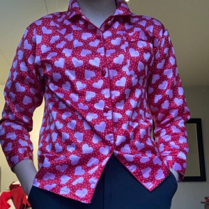 Röd pyjamaströja med hjärtan! - Pjamas-skjorta med hjärtan! Jättesöt pjamasskorta! Passar perfekt nu inför alla ❤️-dag. Har dock ett hål i armhålan (se bild 3) men det går snabbt och lätt att laga!