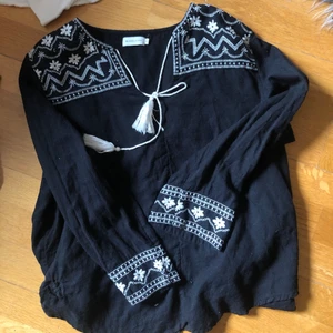 Svart blus 🖤 - Så söt svart blus med vita broderier på🖤🤍 Märket heter Angelology och är köpt på lager 157’s second hand försäljning för några år sen!! 🖤🖤🖤 STORLEK XL men sitter såhär på mig som är S!!  ❤️❤️Nästan aldrig använd!