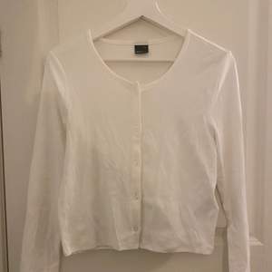 En långärmad vit tröja med knappar från ginatricot, stl xl. Aldrig använd, säljer pga kommer inte till användning. Kostar 60 + frakt. 