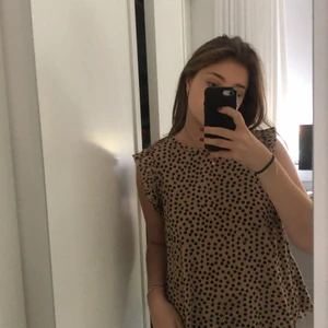 Ett super sött linne!!😍😇 - Ett linne med prickar och volang längst ut på axlarna! Använd en gång.