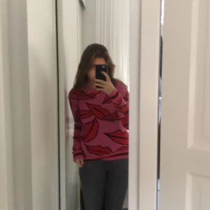 En jättecool rosa stickad tröja!  - En rosa stickad tröja med läppar som detaljer.