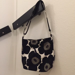 Marimekko axelväska - Axelväska från Marimekko, köptes för 1800kr, använd max 6 gånger så i bra skick. Svart, vit, grön i färg. Priset kan diskuteras och mer bilder kan skickas på begäran! 