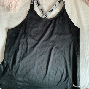 Nike linne - Svart linne från NIKE med lufthål på sidan och öppen rygg