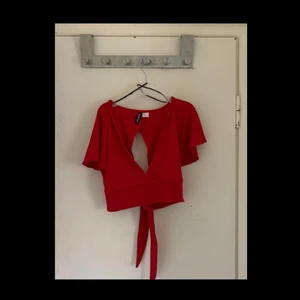 Röd topp - En röd topp som är öppen både där fram och bak, där bak knyter man och där fram är det en vanlig urringning. Aldrig använd! Skicka pm för bättre bilder!😁
