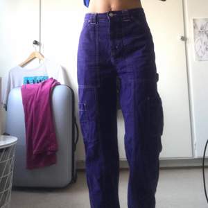 purple cargo jeans with white sews