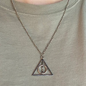 Harry Potter Halsband Deathly Hallows  - Fint silverfärgat halsband med dödsrelikerna från Harry Potter. Kedjan är ca 50 cm lång.