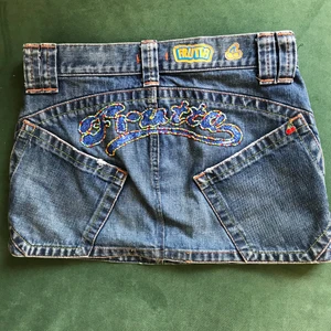 Exotisk jeanskjol  - En snygg jeanskjol med texten Frutta på baksidan . Den har aldrig använts och den är i bästa kvaliten. Midjemåttet är på 73 cm. 🍒 Köpare står för frakt 🍒