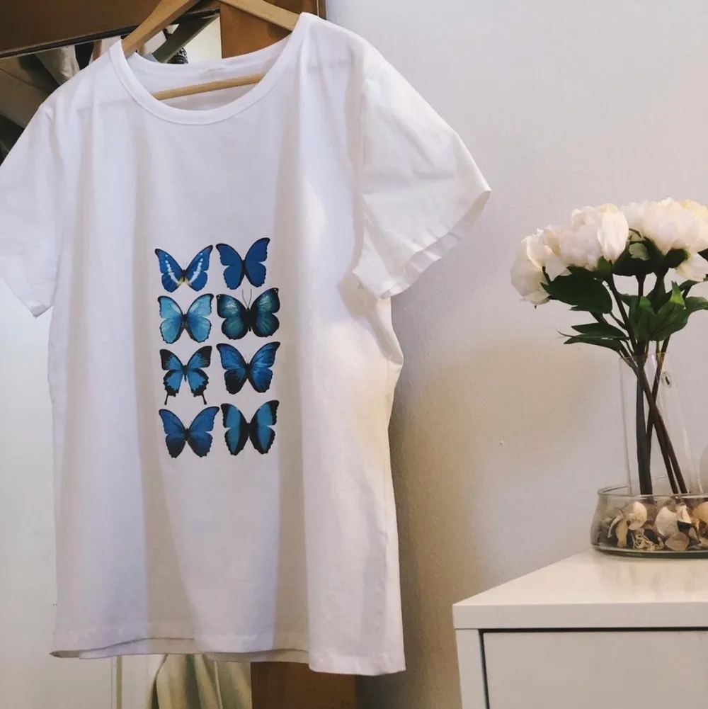 en vit oversize t-shirt med blå fjärilar, egensydd och aldrig använd!! köparen står för frakten . T-shirts.