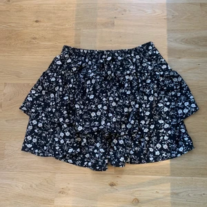 Blommig svart kjol - Säljer superfin blommig kjol då den aldrig kommit till någon användning. Helt oanvänd, bra skick. 💕 kontakta vid frågor eller funderingar!!💗