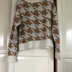 Stickad tröja - Stickad beige/vit tröja med hundtandsmönster🤍Tröjan är väldigt mysig och varm, perfekt en kall vinterdag!💫Orginalpris är 150kr men jag säljer den för 50kr.
