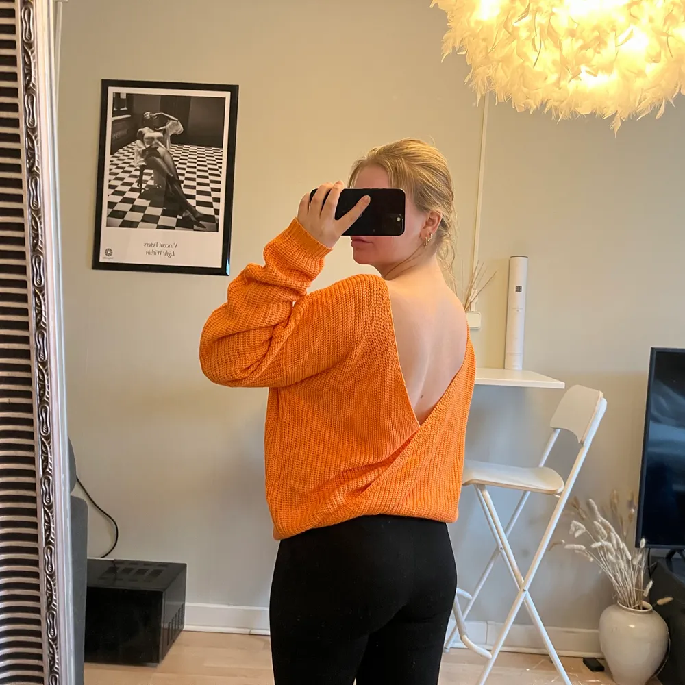 Orange stickad tröja med öppen ryggen i storlek S. Neuleet.