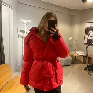 Jacka från NA-KD  - jacka med njut i midjan, i nyskick. Köpt förra året men kommer inte till användning då jag har för många jackor! Band i midjan som både kan knäppas eller knytas. Jackan är klar-röd!