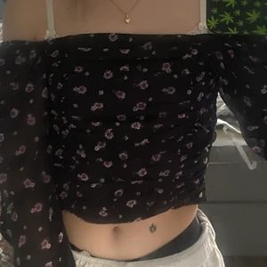 Tröja  - Svart blus liknande topp med lila blommor från HM. Oanvänd 