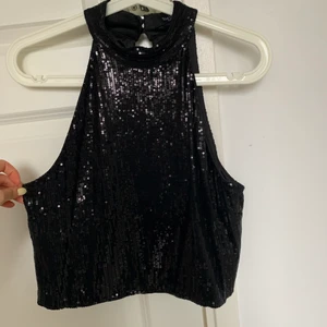 Svart paljett topp - En svart paljett topp med halter neck. Storlek M men passar mig som vanligtvis bär XS/S. 