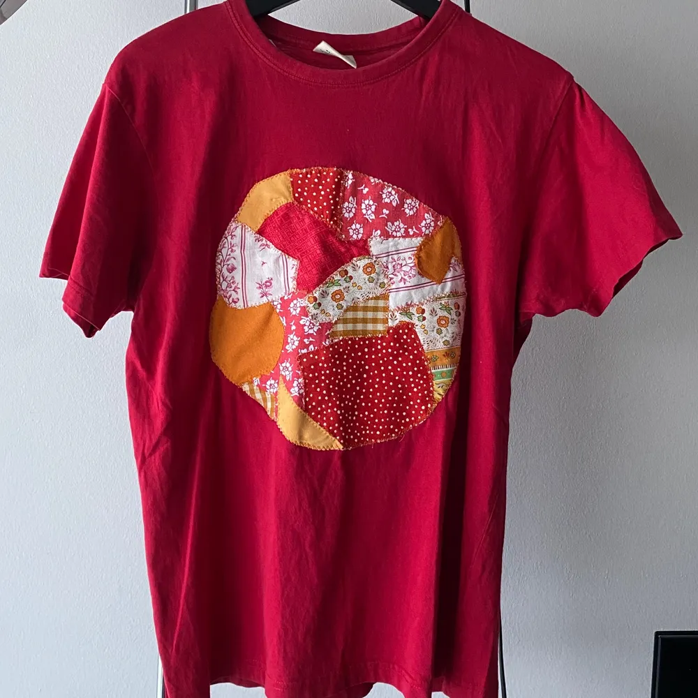 Riktigt snygg röd t-shirt med lapping på framsidan i mass olika tyger🦠❤️. T-shirts.