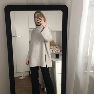 Stickad tröja Zara - En beige lite längre stickad tröja från Zara med hög hals och vida ärmar. Lite ytnoppig. Storlek S. 