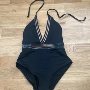 Baddräkt - En baddräkt som även funkar jättebra att bära med kjol en varm sommardag! Jag har endast använt den med kjol, aldrig i vatten. Jättesexiga detaljer fram och den får en jättesnygg passform på kroppen! Storlek xs!