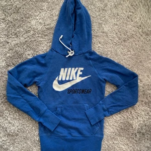 Nike Hoodie, Stk XS - Jag säljer denna blåa Nike hoodie eftersom den är för liten nu, den är i bra skick och skulle kunna användas till hemmamys eller även styla till ett par snygga jeans! Den är i Storlek XS.