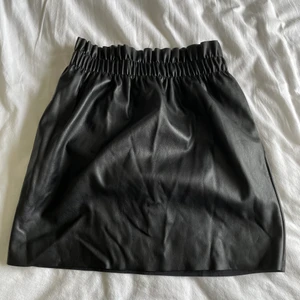 Skinnkjol H&M - Svart kjol med stretch i läderimitation från H&M. Har fickor!!! Använd endast ett fåtal gånger och är i mycket gott skick. Strl. 34