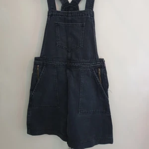  - Svart hängselkjol i jeans, bra skick! Fickor med dragkedja. 100kr+frakt! 