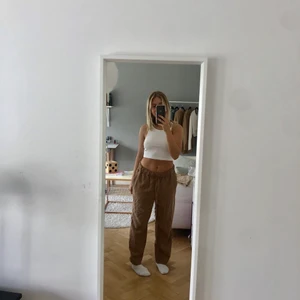 Linnebyxor  - Ett par jättesnygga beiga/bruna linnebyxor från HM. Säljer pga kommer inte till användning. Går som man ser på bilderna jättebra att ha byxorna både havöågmidjat och högmidjat.