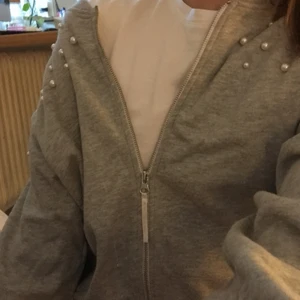 Grå kofta med pärlor  - Det är en grå jättemjuk kofta från Lindex med pärlor på axlarna. Insidan är lurvig och jättemysig✨ storleken är 146/152, men passar större eftersom den är lite oversized. Var inte så förtjust i den så bara använd några få gånger💕 pris kan diskuteras. 