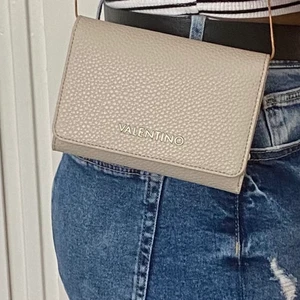 märkesväska  - helt oanvänd beige plånbok från valentino. Jag har satt fast ett axelband och kan därför också användas som en axelväska.