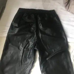 Ett par svarta clean läder byxor 