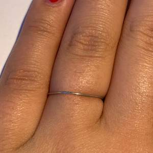 Silver ståltråd ring som är öppen där inne och den kan gå upp ibland med då är det bara att trycka tillbaks den på fingret.