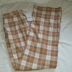 Rutiga kostymbyxor från Misslisibell×NA-KD. Aldrig använda pga för långa samt för stora. Nypris ca. 400 kr. Kan gå ner i pris, vill bara få dom sålda.