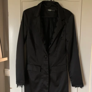 Oanvänd kostymklänning - En helt oanvänd blazer klänning från Missguided i satin, lagom urringning med knäppning nedtill.