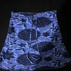 Floral mini skirt  - Fin, floral, vintage mini skirt. Knappt använd pga att den var lite stor i midjan. Materialet är ganska så stretchigt och så har kjolen snören vid midjan ifall man vill göra den tajtare eller bara ha som en liten detalj. Storleken som står är 110/116 men den var lite lös på mig som är en XXS/XS. Skulle själv gissa på att den passar XS-S.