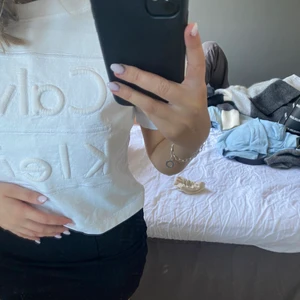 T-shirt från Calvin Klein  - Vit T-shirt i perfekt passform. Supersnyggt och stilrent Calvin Klein tryck fram som ”sticker ut”. Storlek XS