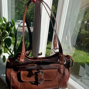 Handväska - Säljer en jättefin väska i den perfekta storleken! Inte för stor men man får plats med mycket😊. Väskan är vinröd i någon slags skinn liknande modell. Bra kvalitet och nästan aldrig använd🙏 har för många väskor så säljer billigt eftersom den inte kommer till användning💗 Skriv för mer bilder eller frågor! Möts helst upp på söder/hägersten💖