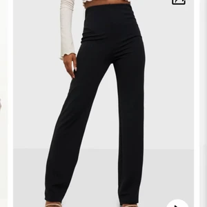 Nelly crêpe pant kostymbyxa - Svarta stretchiga kostymbyxor från Nelly❤️ mina absoluta favoritkostymbyxor, sitter så otroligt snyggt samtidigt som det känns som man har på sig mjukisbyxor🥰 storlek xs och uppsydda av skräddare, passar dig som vanligtvis har 30 längd på byxor!! Köper man dessa på nelly är de väldigt långa, passar dem som är upp mot 180. Välanvända men ändå i ett gott skick. 