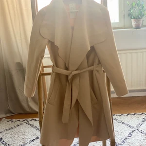 Ny Kappa. Storlek M - Ny tunn kappa i beige. Med tags kvar!