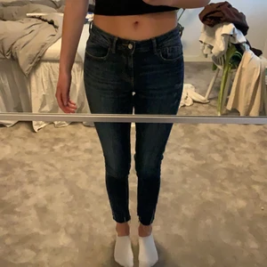 Lågmidjade jeans - Lågmidjade jeans från Zara med slitningar vid vristerna. Strkl 36, mörkblå färg, stretchiga.