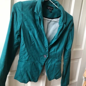 Kavaj från Topshop - Jättefin Kavaj från topshop i storlek 36, inga slitningar!  Den är av kortare modell, på mig som är 175 cm slutar den nedanför midjan.