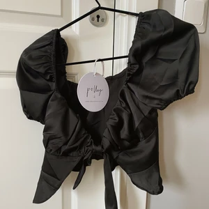 Kort topp med knytning - Silkes material, perfekt till ett par högmidjade jeans! Aldrig använd