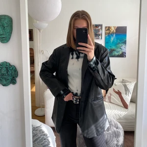 Kavaj i skinnimitation - En svart kavaj i skinnimitation från monki. Boxig och oversized modell. Använd sparsamt, därav i bra skick. Köpare står för frakt.
