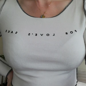 Croptop från Topshop strl. 6 - Vit ribbad croptop från märket Topshop med svarta kontrast sömmar och svart text på bröstet i sammet med texten "For Love's Sake" aldrig använd. 