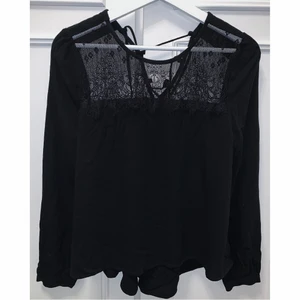 Svart blus med spets - Svart blus med spets bak och fram + snörning bak. Från Forever21 i storlek S. Använd några få gånger så fint skick!