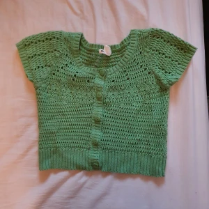 Grön topp - Säljer min stickade gröna topp i st xs ifrån hm, jätte fin till sommaren, jätte fint skick och använd ett fåtal gågner. Hör av er vid intresse🥰
