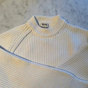 Stickad tröja Acne studios  - Säljer denna mysiga stickade tröja från acne. Kort modell så slutar precis ovanför höften, perfekt till lågmidjade byxor. Snygga muddar och detaljer. Knappt använd, men en liten fläck finns på vänster arm (se bild 3) därav lägre pris. Annars bra skick. Passar definitivt XS men även M om man vill ha den lite kortare